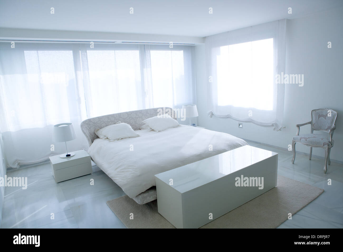 Moderna casa bianca camera da letto con pavimento in marmo e luminose vetrate Foto Stock