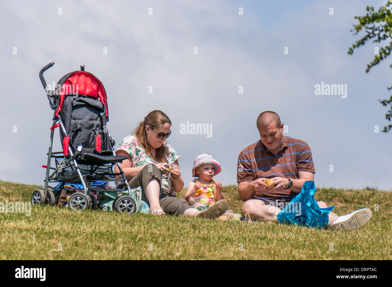Una coppia e il loro bambino avente un picnic su Box Hill, Surrey, Inghilterra Foto Stock