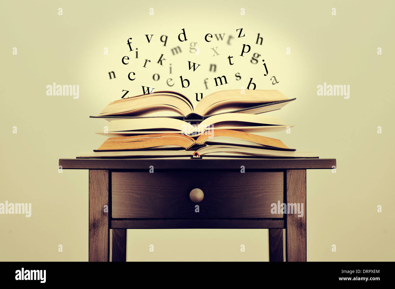 Una pila di libri e lettere che fluttua sopra di loro su una scrivania che simboleggiano l idea di letteratura o di conoscenze Foto Stock