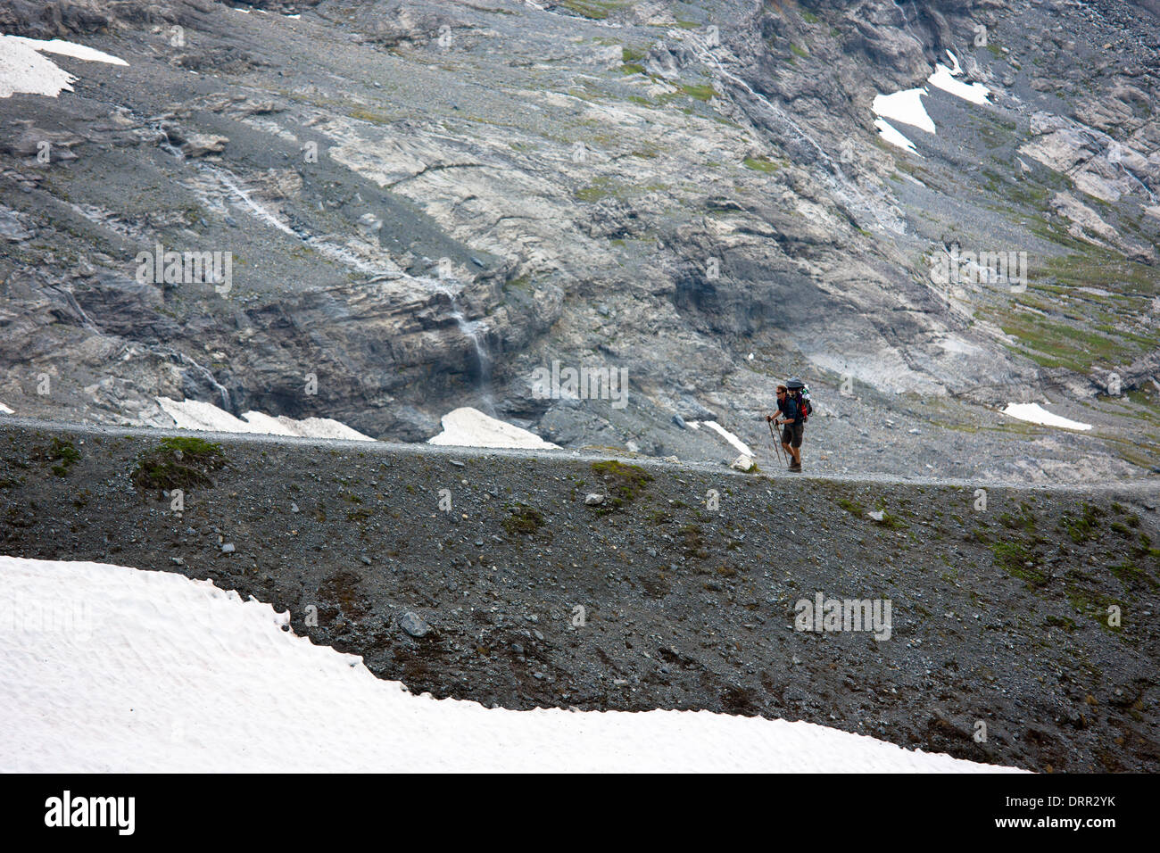 Escursionista con attrezzatura da campeggio sul Eiger Trail dal ghiacciaio Eiger, Eigergletscher, nelle alpi svizzere, Oberland bernese, Svizzera Foto Stock