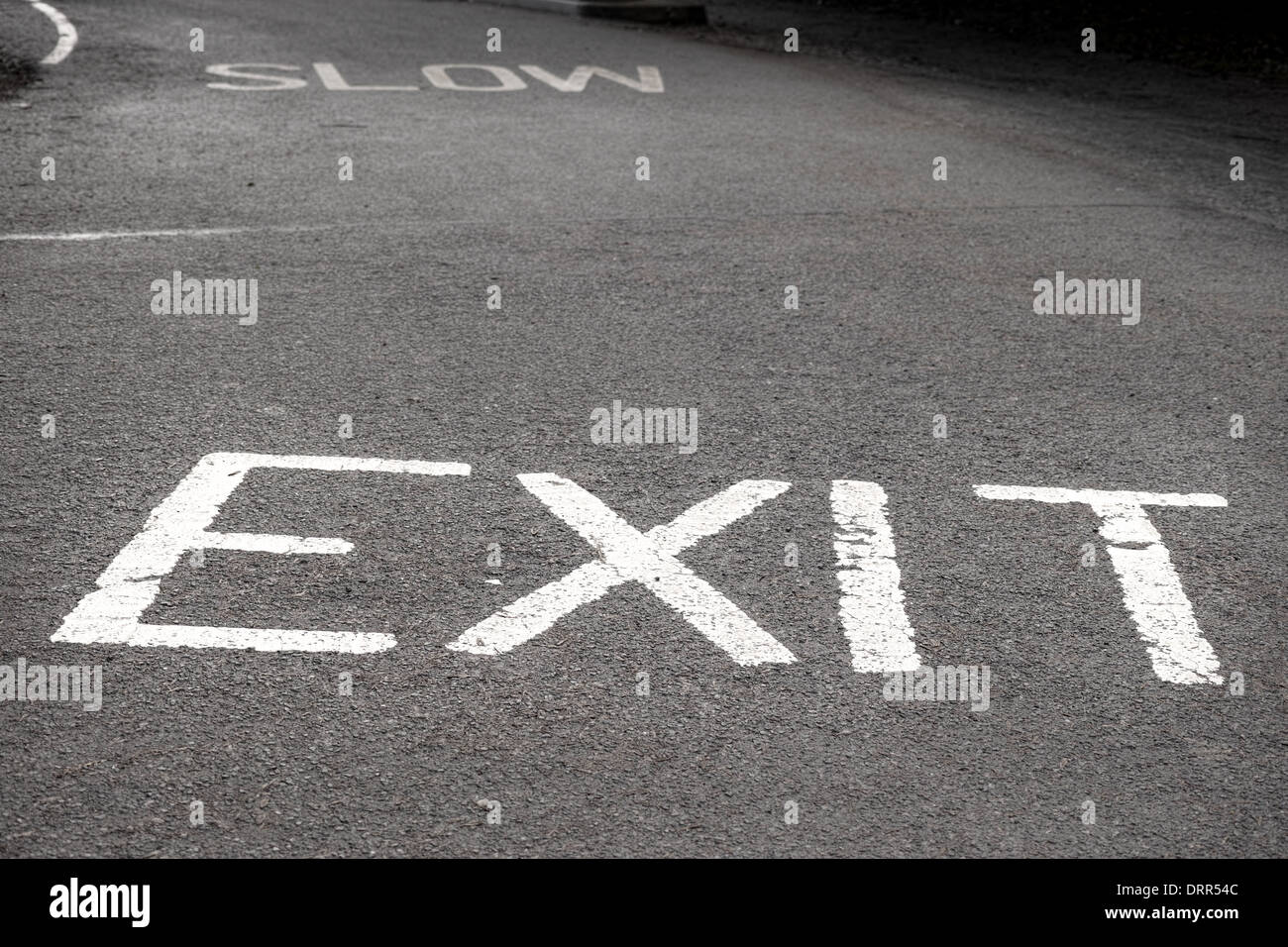 Segnale di uscita scritto in vernice bianca su una strada asfaltata per mostrare i piloti la via di uscita. Foto Stock