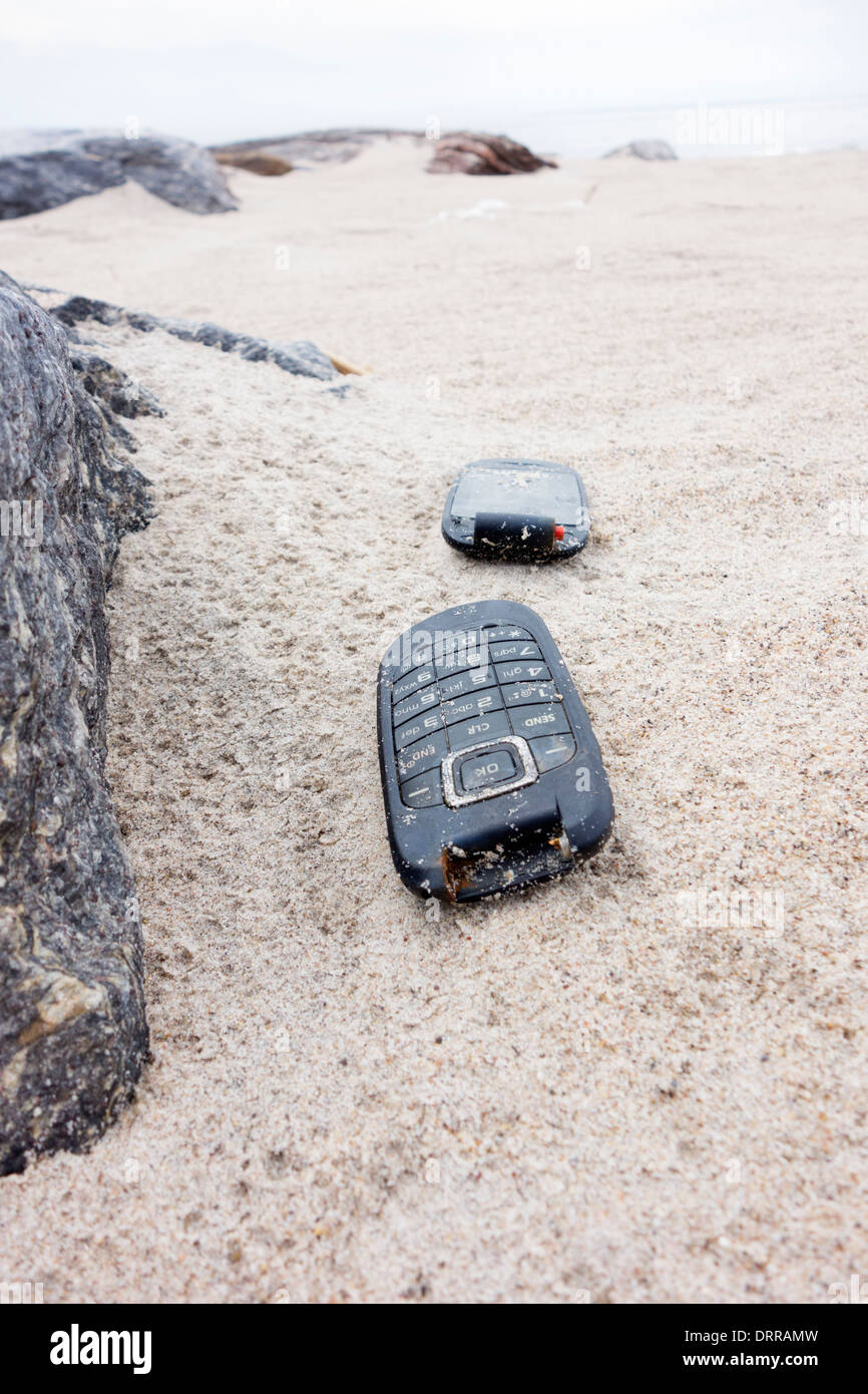 Stati Uniti d'America, New York, Brooklyn, Coney Island: danneggiato telefono mobile che giace su di una spiaggia di sabbia Foto Stock