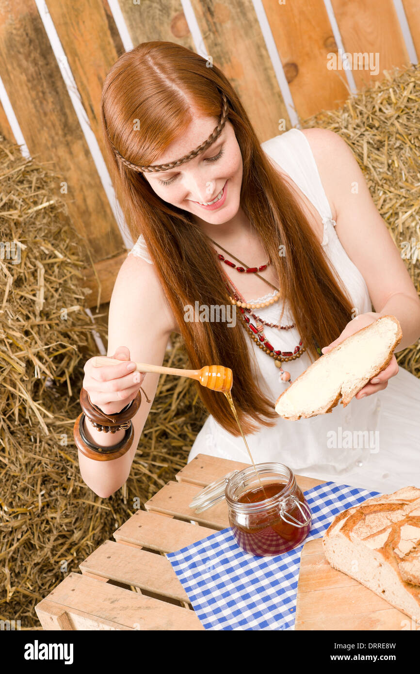 Redhead hippie donna hanno la colazione nel fienile Foto Stock