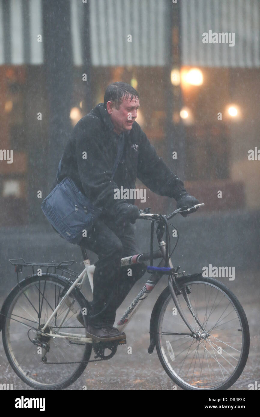 Uomo in bici in pioggia in Cambridge Foto Stock