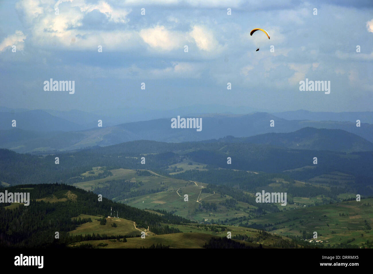 Parapendio in montagna sopra il paese Foto Stock