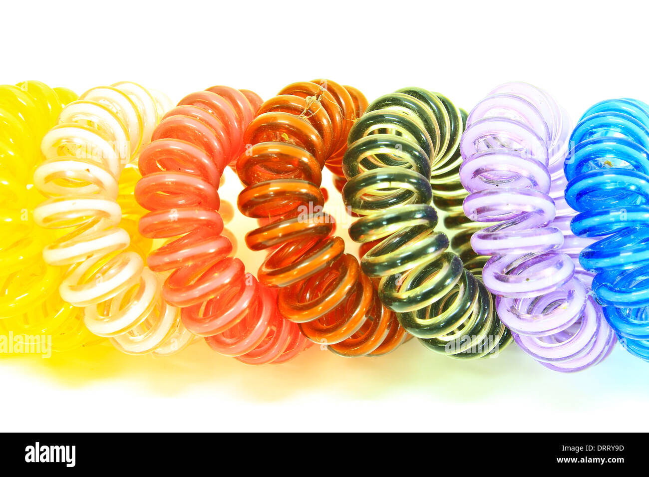 Spirale colorata capelli elastici tiranti utilizzati su uno sfondo bianco. Foto Stock