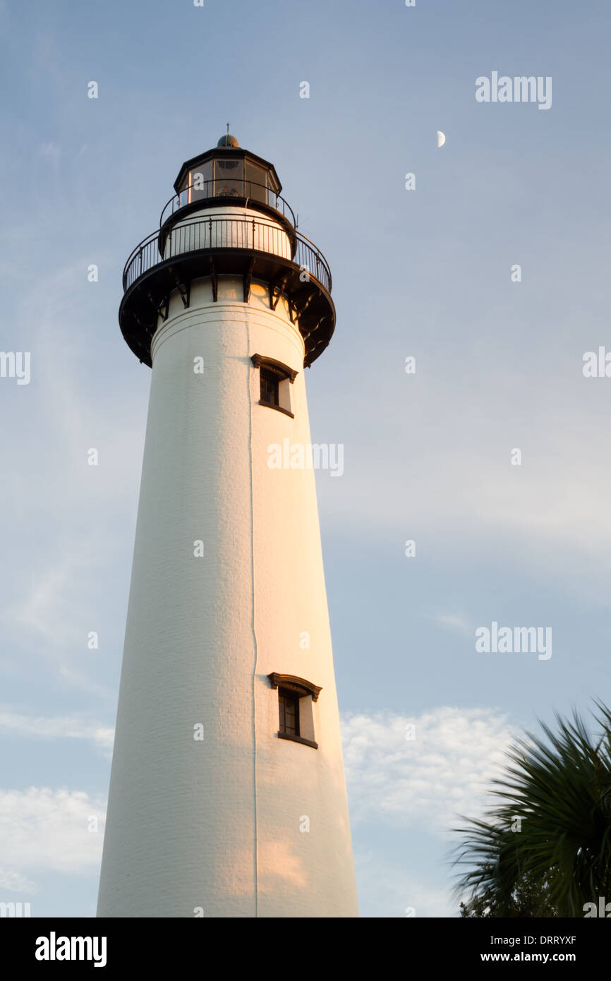 San Simons Island Lighthouse al crepuscolo con una mezza luna impostazione nelle vicinanze. Foto Stock