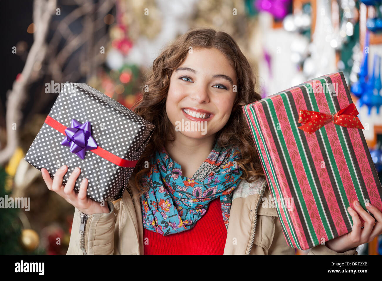 Donna che mantiene i regali di Natale nel negozio Foto Stock