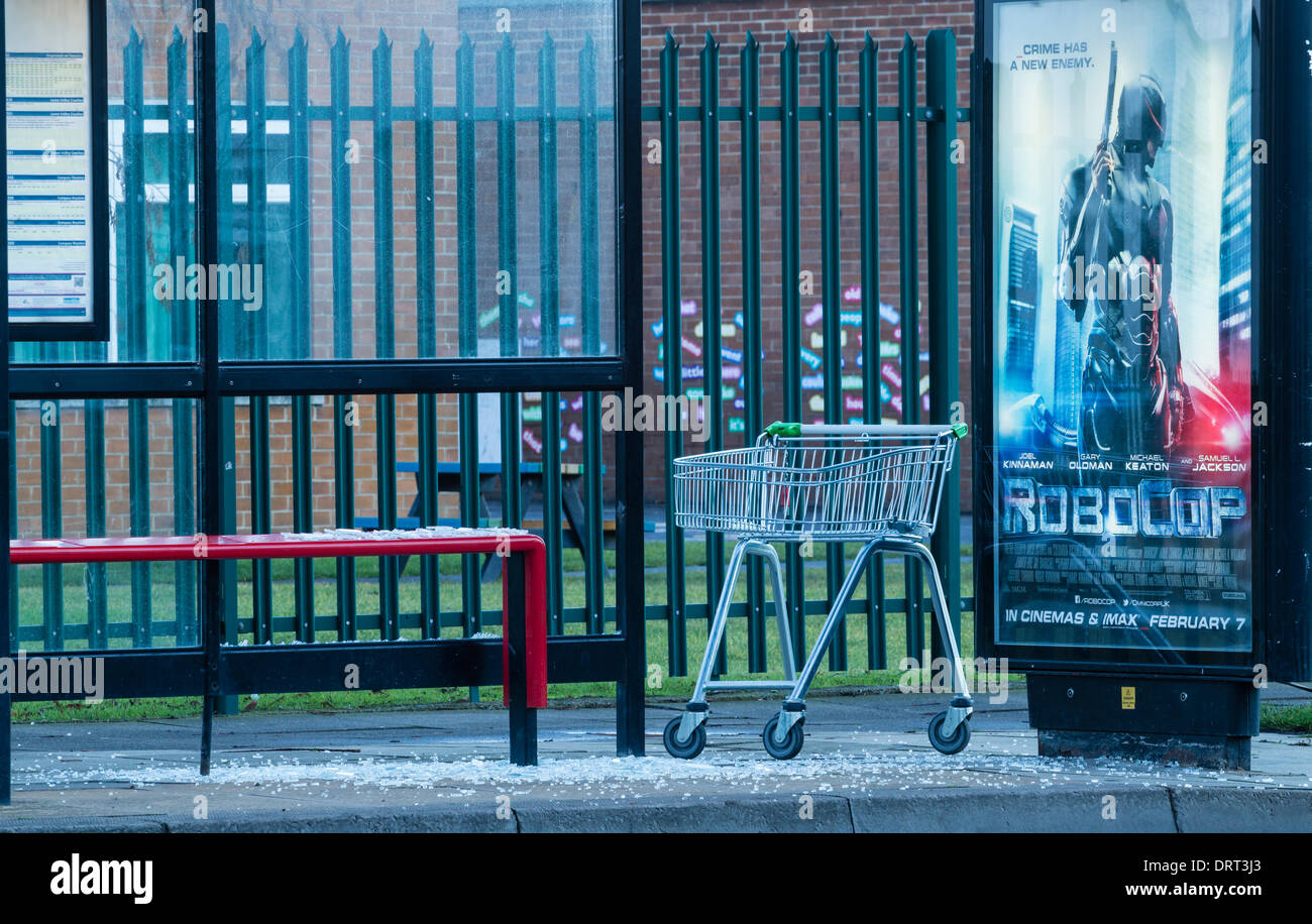 Poster per Robocop film dice "crimine ha un nuovo nemico' in Bus shelter vanadlized con carrello della spesa. Foto Stock