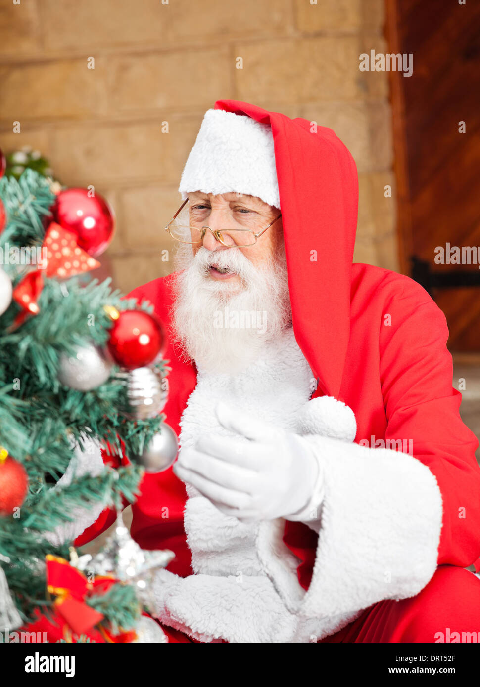 Uomo vestito da Babbo Natale Decorare albero di Natale Foto Stock