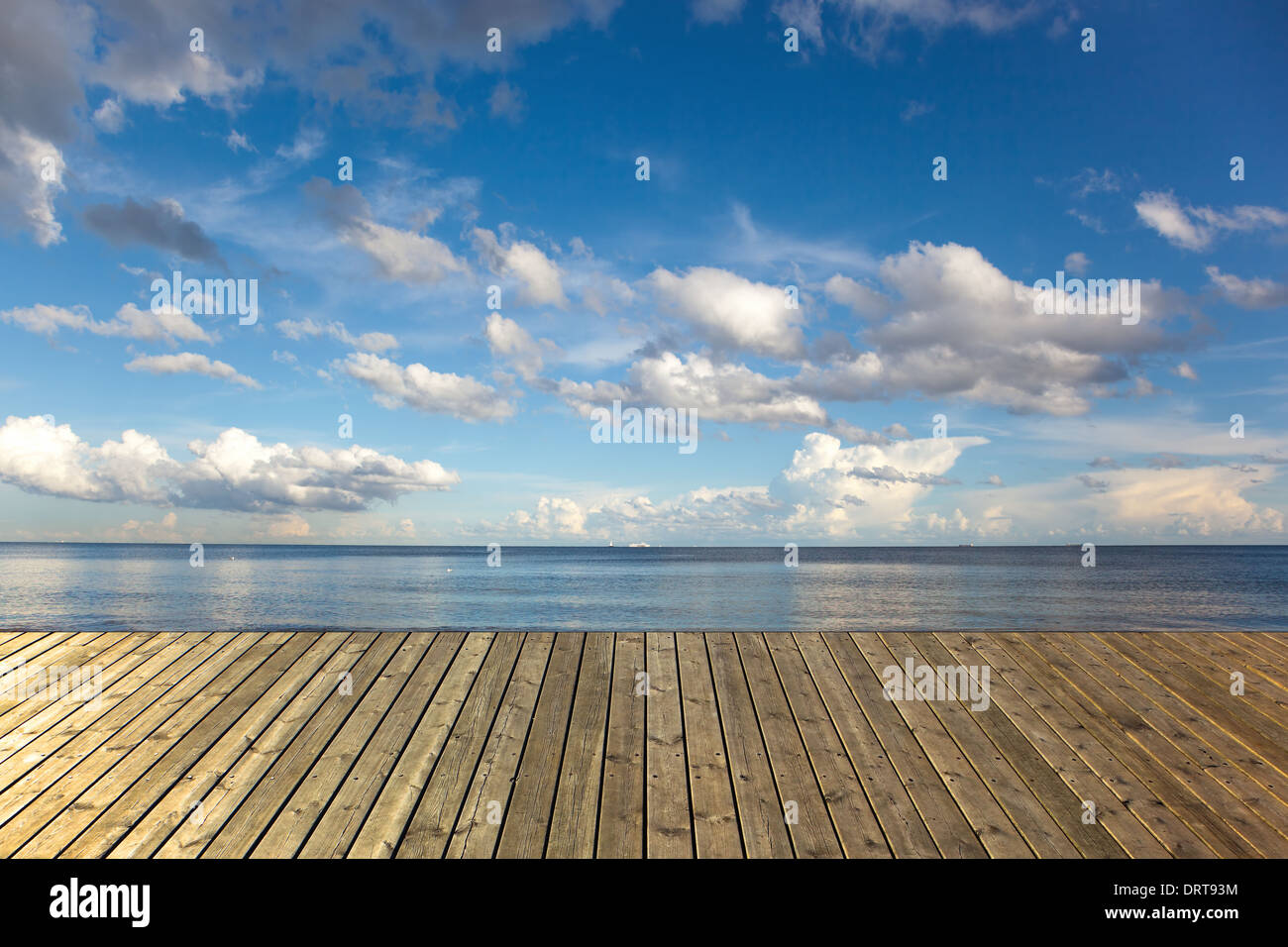 Svuotare il molo in legno su un mare con il cielo blu e nuvole. Foto Stock