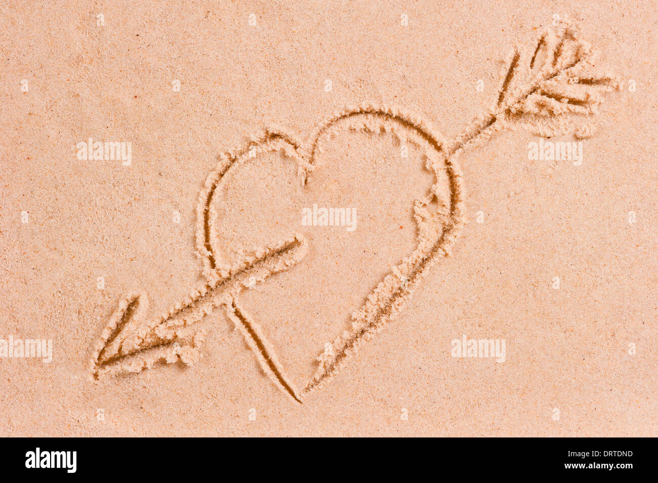 Disegno di un cuore con una freccia sulla sabbia bagnata Foto Stock