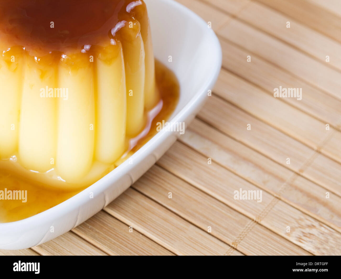 Dettaglio di un caramello crema pasticcera su un sfondo di bambù Foto Stock