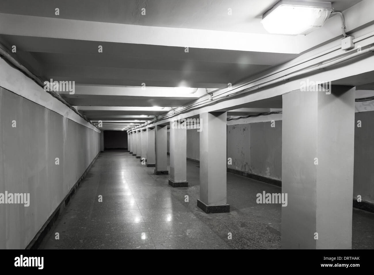 Passaggio sotterraneo interno con luci e colonne di cemento Foto Stock