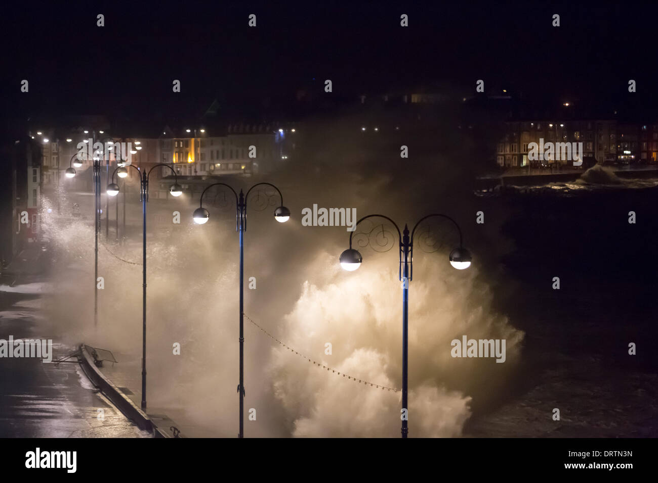 Aberystwyth, Wales, Regno Unito. Il 1° febbraio 2014. Aberystwyth è martoriato da una serata Spring Tide e onde pilotato da venti alti. La passeggiata è stata chiusa dalla guardia costiera, Consiglio dei lavoratori e polizia. Diverse centinaia di studenti universitari in sale sul lungomare in precedenza era stato spostato per un alloggio sicuro. Credito: atgof.co/Alamy Live News Foto Stock