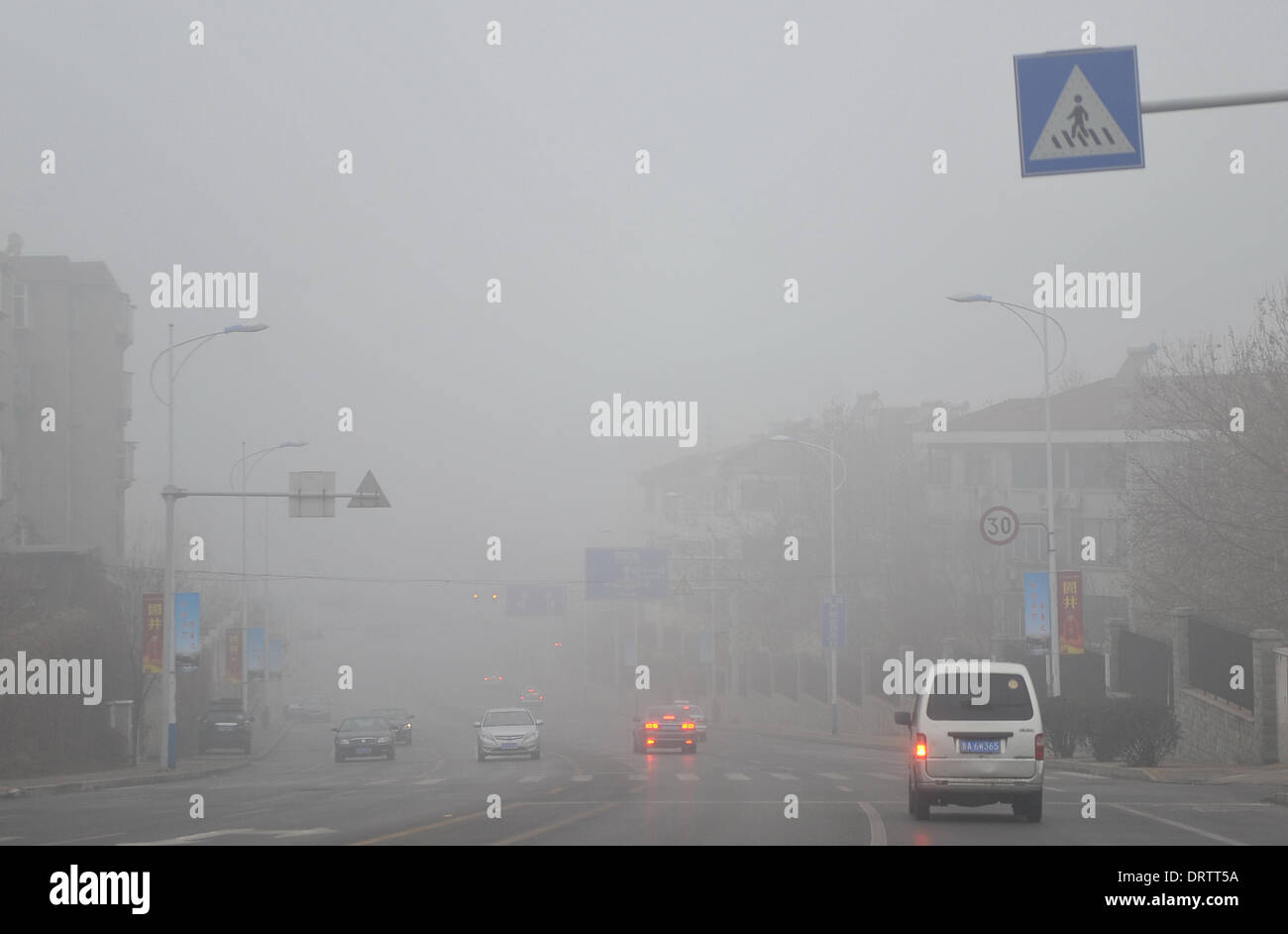 Jinan, la Cina della provincia dello Shandong. 2° febbraio 2014. Autovetture correre in mezzo pesante velatura di Jinan, a est della capitale cinese della provincia dello Shandong, Febbraio 2, 2014. Meteo locale ufficio di presidenza rilasciato pesante velatura e il fronte freddo allarme su 2 febbraio, una previsione 8-10 gradi Celsius goccia dal febbraio 2 febbraio al 4. Credito: Zhu Zheng/Xinhua/Alamy Live News Foto Stock