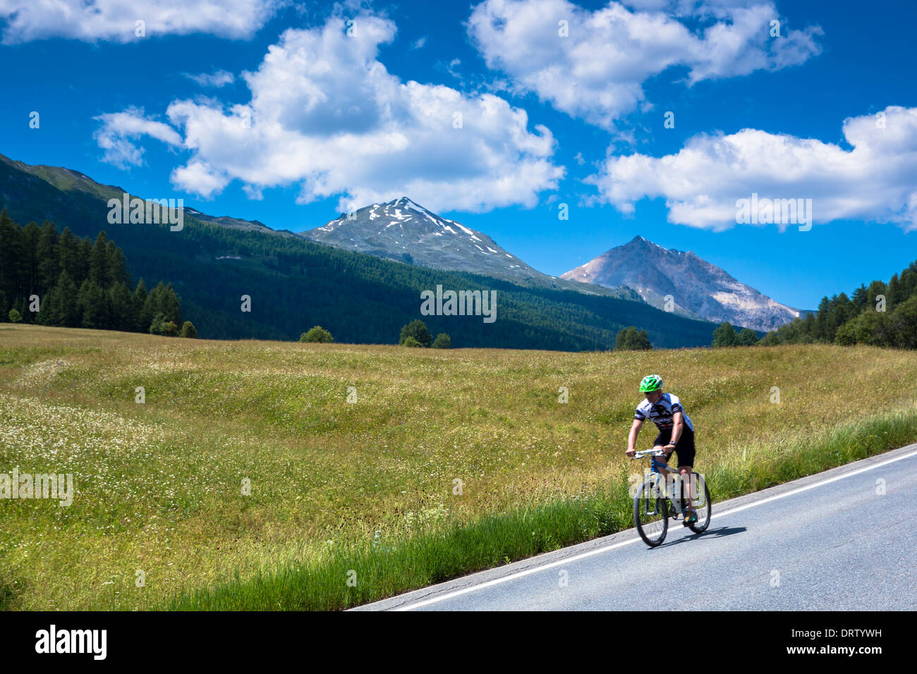 In discesa in bicicletta nel Parco Nazionale Svizzero con lo sfondo delle alpi svizzere, Svizzera Foto Stock