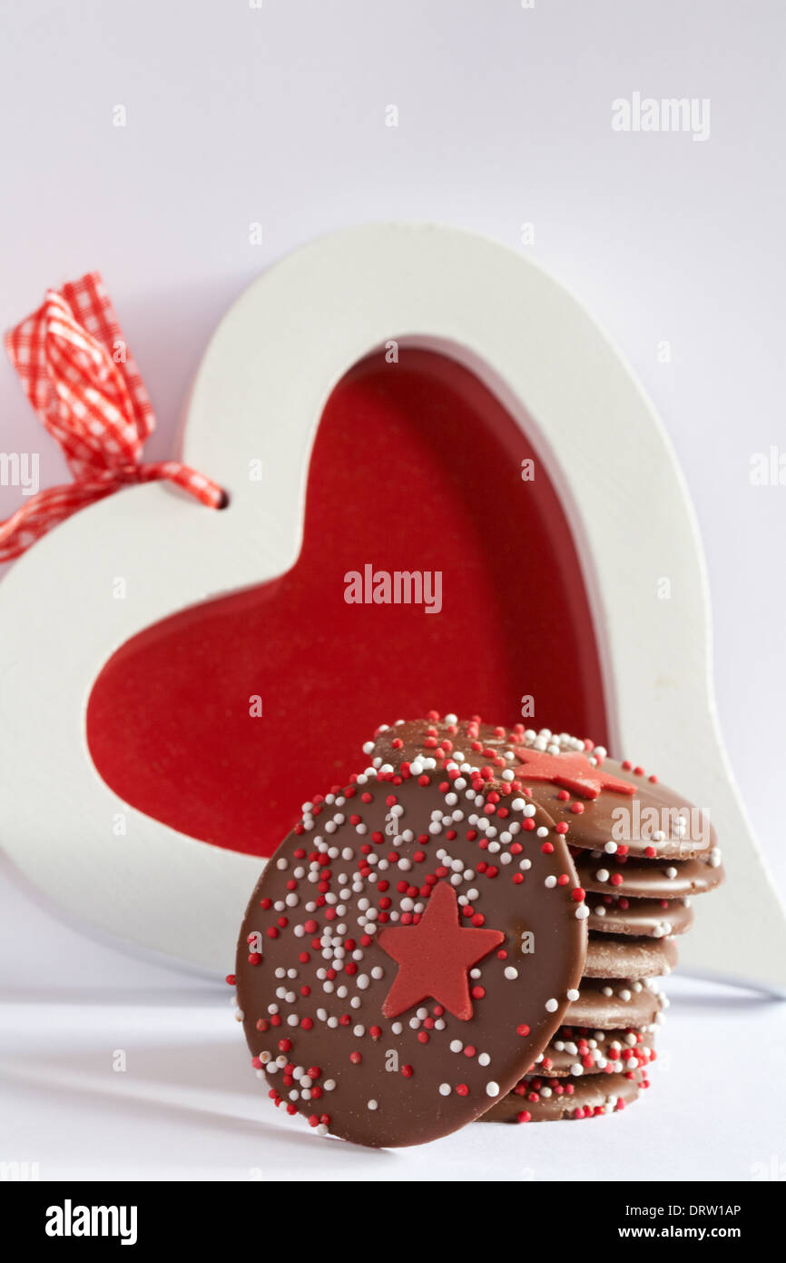 Pila di Linden Lady cioccolato artigianale pulsanti, Linden Lady cioccolatini, stelle giganti pulsanti di cioccolato senza glutine nella parte anteriore del telaio del cuore impostato su bianco Foto Stock