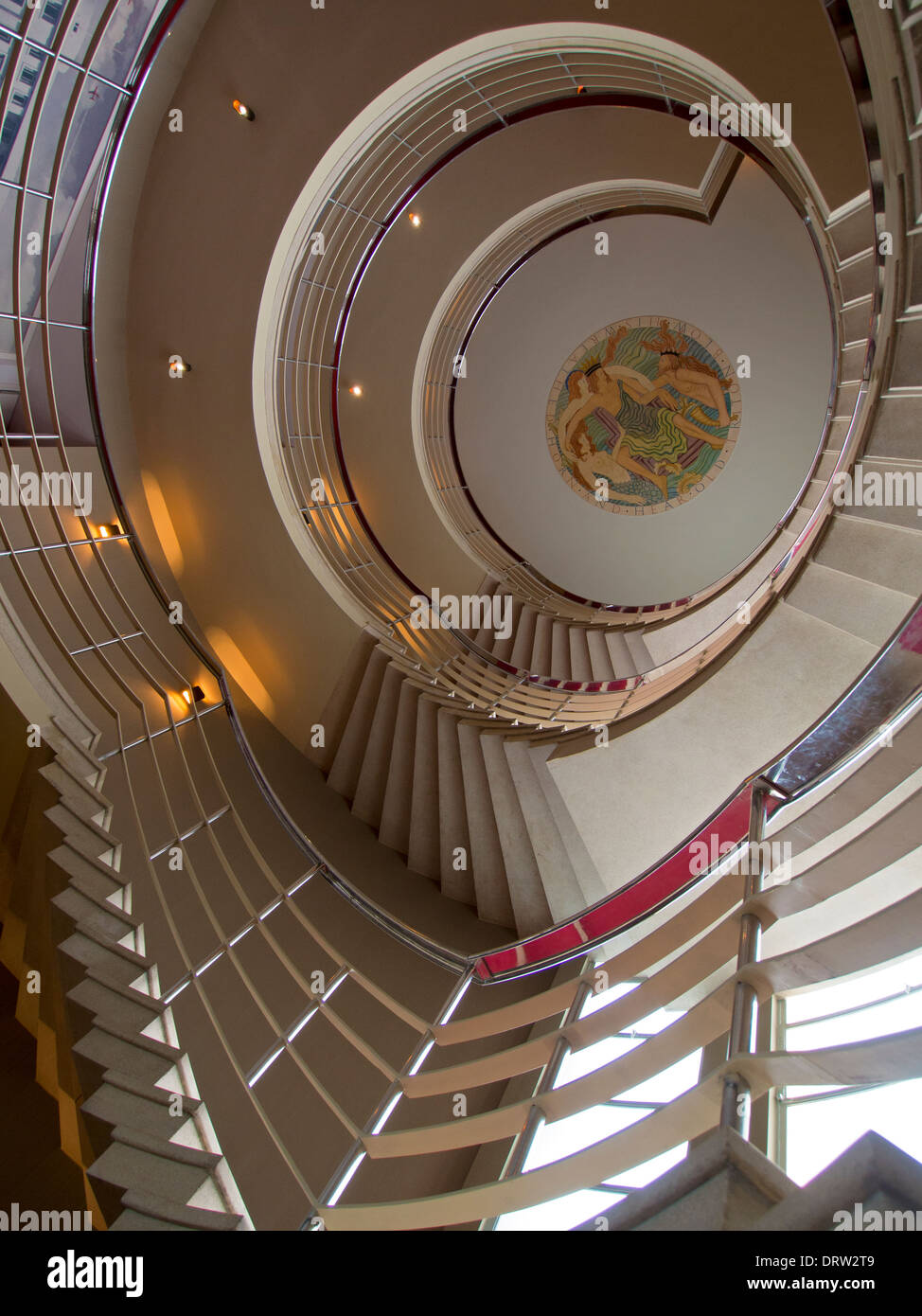 Una grande scala a spirale in stile Art Deco che conduce verso un soffitto che reca un originale Eric Gill dipinto bassorilievo scultura Foto Stock