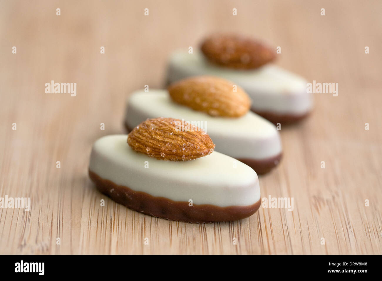 Tre cioccolati di lusso su una scheda di bambù. Foto Stock