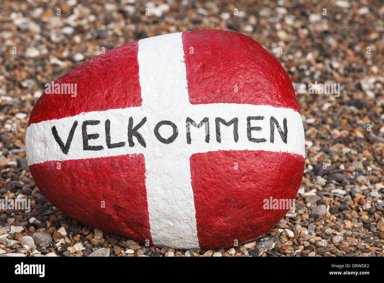 Pietra dipinta con bandiera della Danimarca e la scritta "Benvenuto" Foto Stock