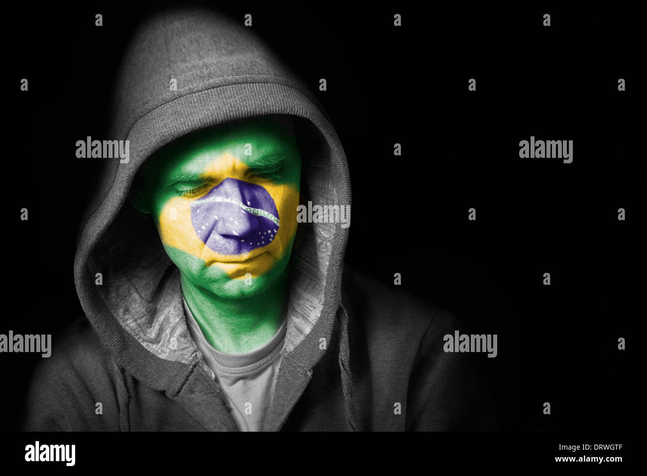 Un triste espressione sul viso di un tifoso di calcio con il loro volto dipinto con la bandiera brasiliana. Foto Stock