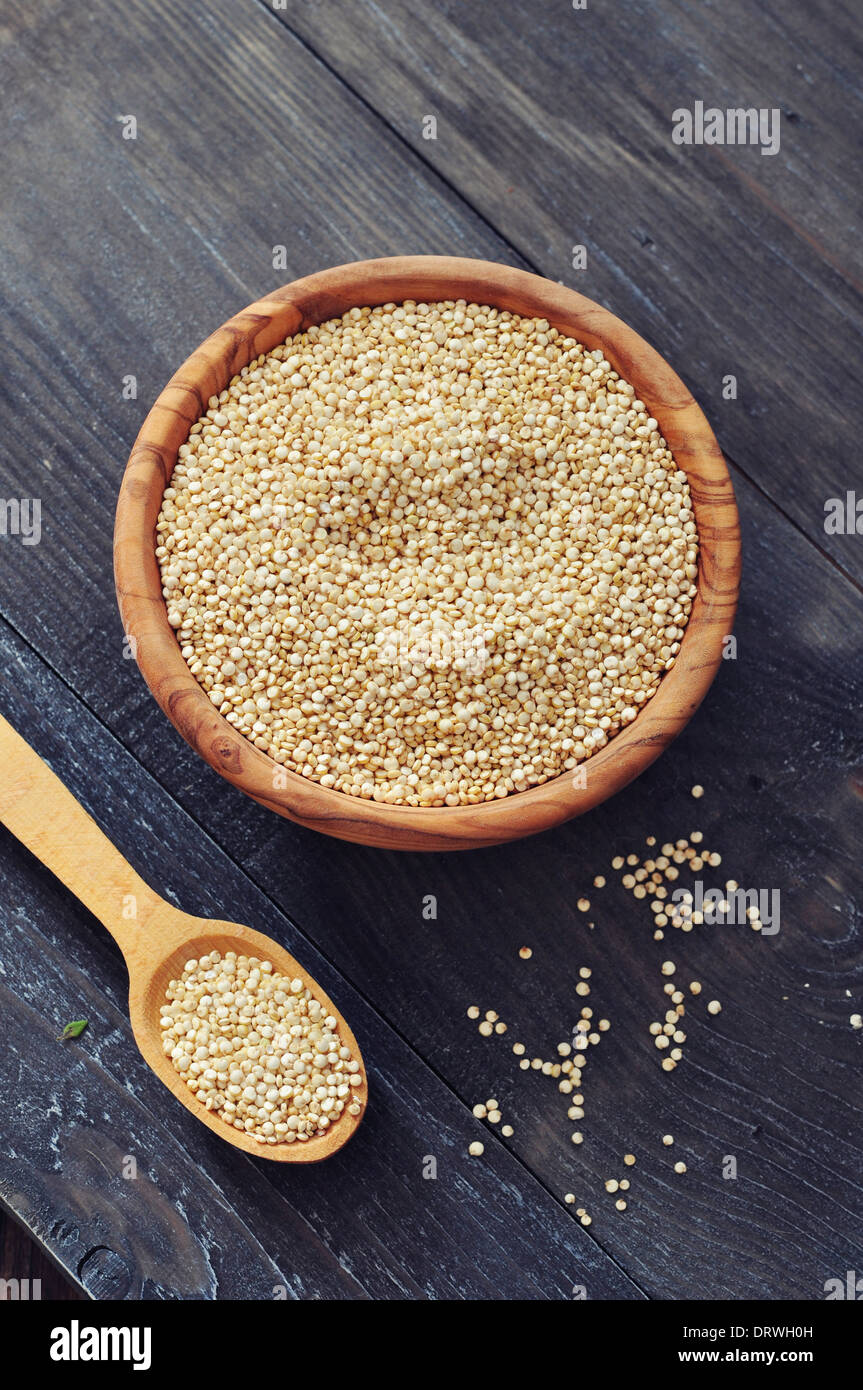 Materie di quinoa semi nella ciotola di legno su sfondo di legno closeup Foto Stock