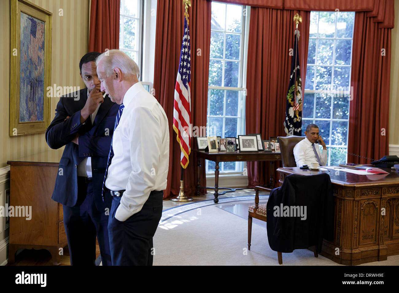 Vice Presidente USA Joe Biden conferisce con Rob Nabors, vice capo di Stato Maggiore per la politica come il Presidente Barack Obama parla al telefono con il presidente francese François Hollande discutendo la Siria dall'Ufficio Ovale della Casa Bianca Agosto 31, 2013 a Washington, DC. Foto Stock