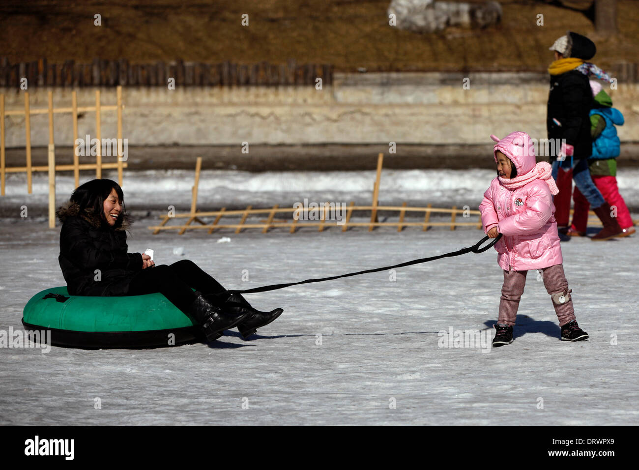 Pechino, Cina. 3 febbraio, 2014. Una giovane ragazza e sua madre per godere di ice-tubing al Parco Taoranting a Pechino Capitale della Cina, Febbraio 3, 2014. Artificiale di sport invernali piste sono diventati una alternativa per i turisti e per i residenti locali di Pechino che vogliono esposizione al ghiaccio e neve, come città testimoniò nessuna significativa nevicata di questo inverno. © Shen Bohan/Xinhua/Alamy Live News Foto Stock