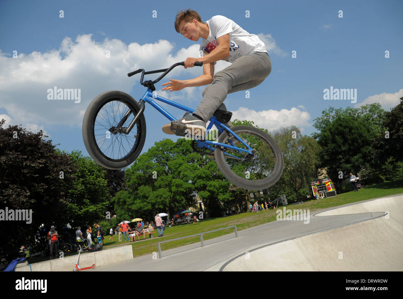 Un giovane biker salta con la sua bicicletta in un urbano bike park. Foto Stock