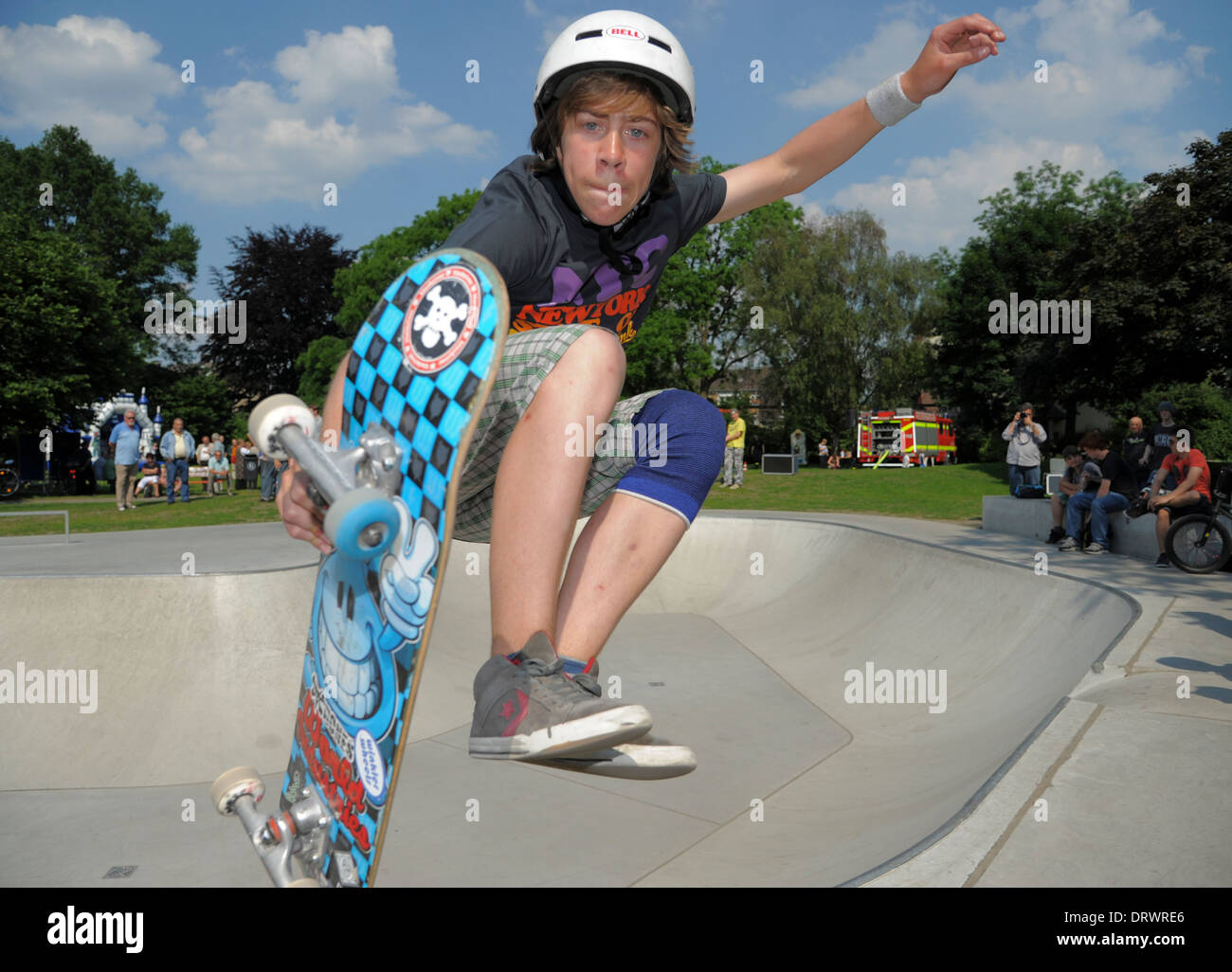 Un giovane guidatore di skateboard salta con il suo skateboard in un urbano skateboard park. Foto Stock