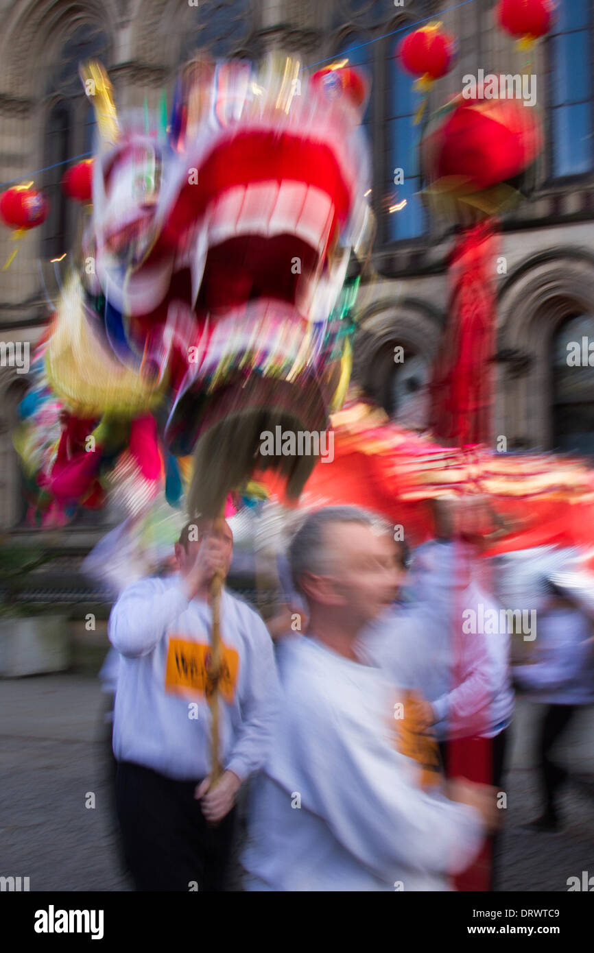 Costume cinese zodiaco animali. Tradizionale Golden Capodanno drago festival di danza a ChinatownFebbraio, 2104. Figure fuori fuoco High pole dragon dance al Capodanno cinese in Albert Square, Manchester il più grande del Nord festeggiamenti di Capodanno cinese. La Chinatown di Manchester è una delle più grandi d'Europa nascosta in una stretta griglia di strade dietro i Piccadilly Gardens. Con un drago di carta di 175 piedi, una danza del leone, dimostrazioni di arti marziali, la Dragon Parade è uno dei momenti salienti del calendario annuale degli eventi di Manchester. Foto Stock