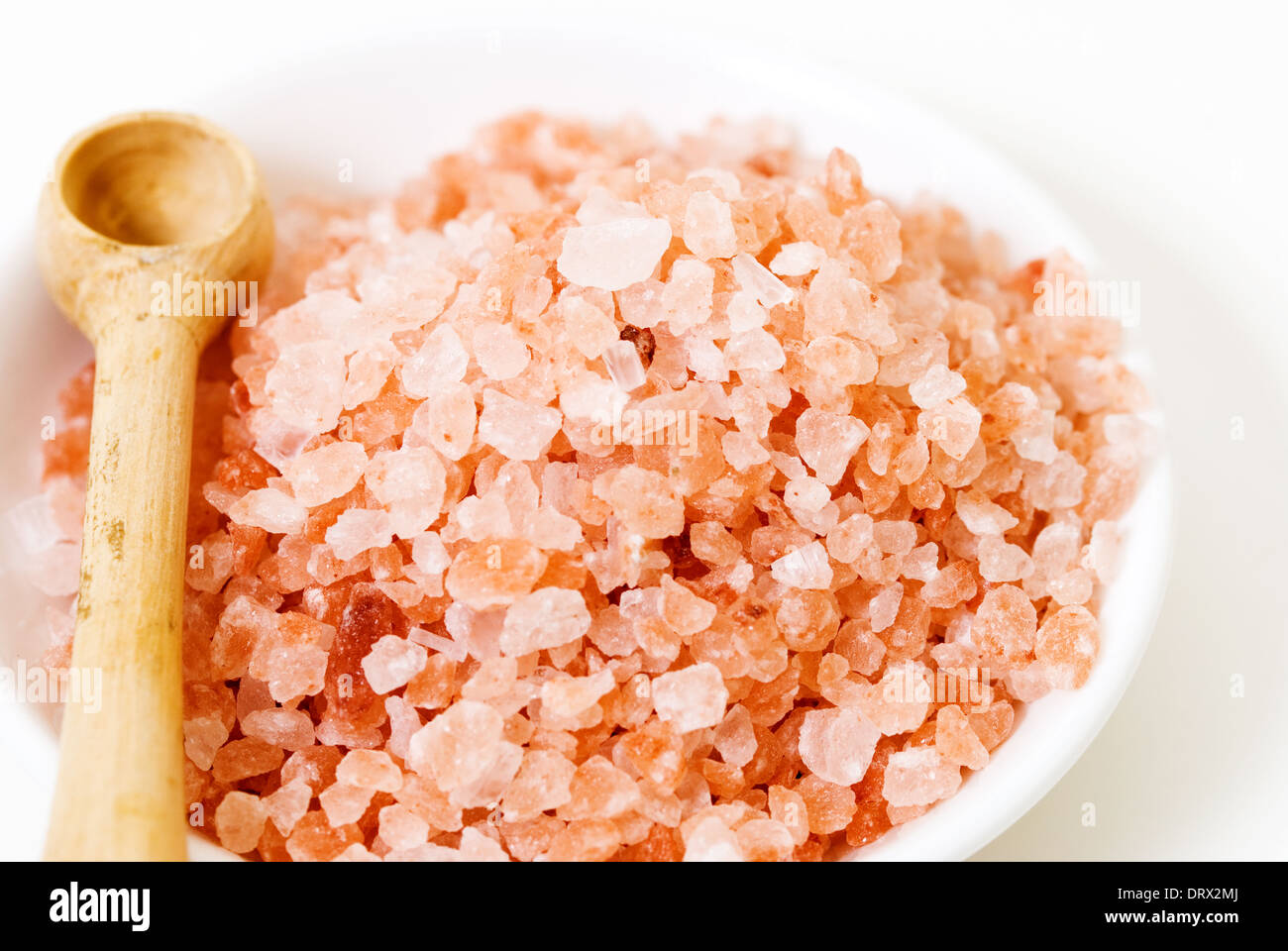 Rosa himalayano il cristallo di rocca sale da tavola di legno di scoop. Foto Stock