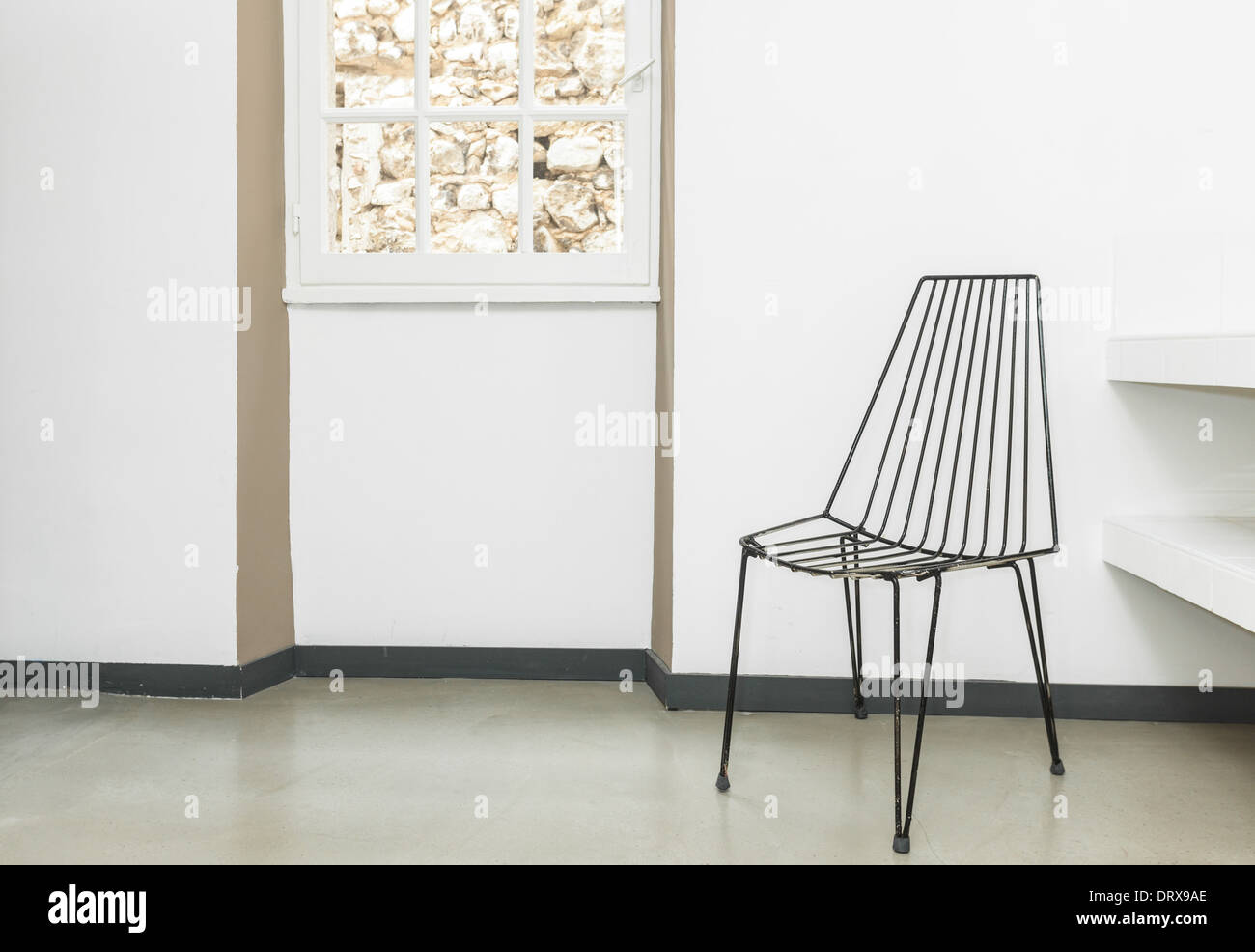 Sedia in fili nella stanza vuota con le pareti bianche. Foto Stock