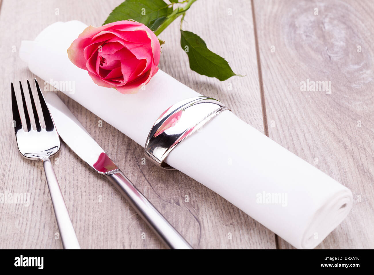 Romantico elegante formale messa in tavola con una sola rosa rosa e nastro decorativo per un innamorato il giorno di San Valentino Foto Stock