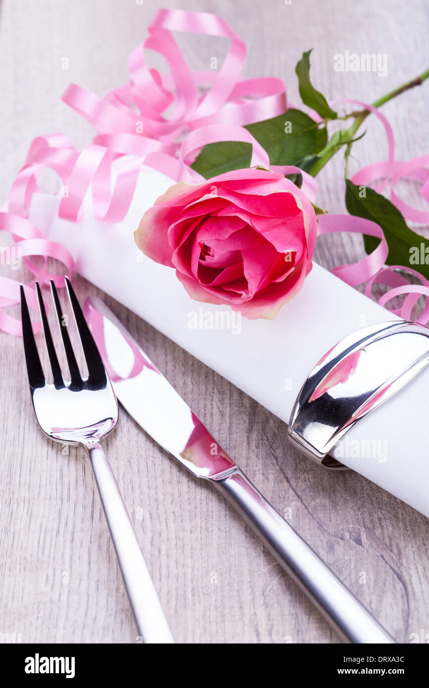 Romantico elegante formale messa in tavola con una sola rosa rosa e nastro decorativo per un innamorato il giorno di San Valentino Foto Stock