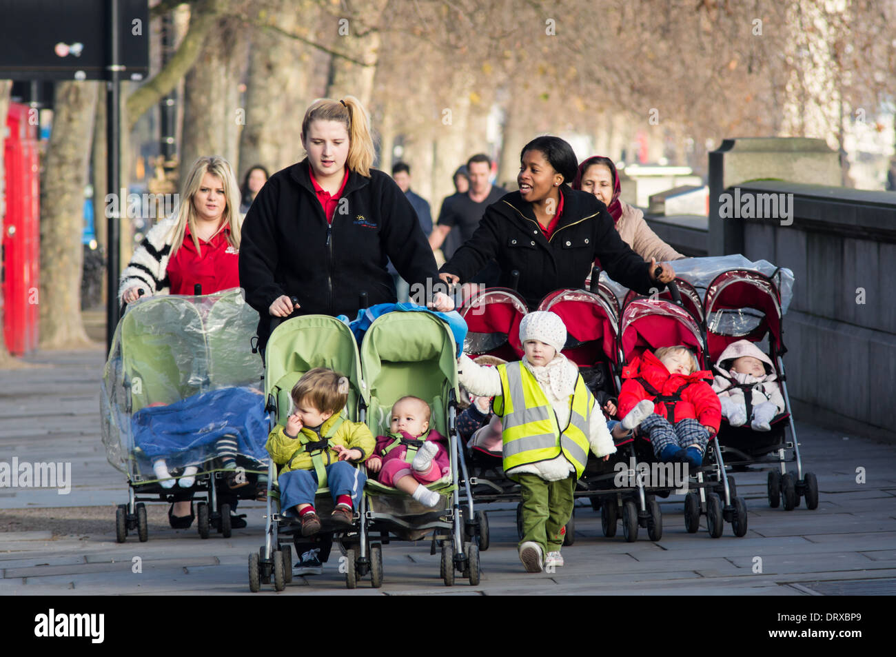 Giovani madri a piedi lungo il Tamigi bank su una mattina dei giorni feriali, Londra England Regno Unito Regno Unito Foto Stock