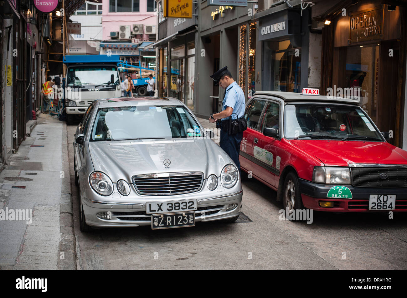 Uomo di polizia multare un indebitamente parcheggiate auto Mercedes in Gough Street. La Vettura dispone inoltre di una Cina continentale numero di targa Foto Stock