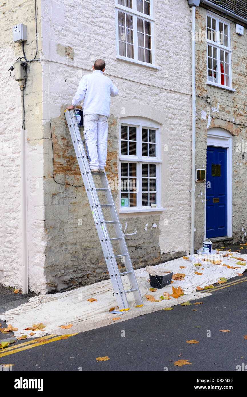 La verniciatura di una vecchia casa di villaggio in Highworth, Wiltshire. Foto Stock