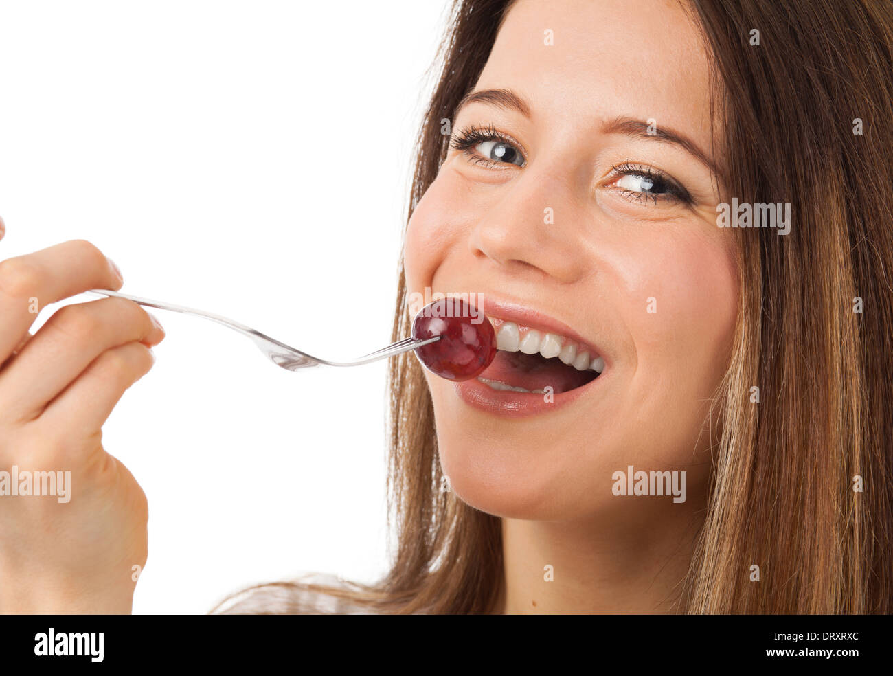Close up ritratto di una bella donna di mangiare uva, isolato su bianco Foto Stock