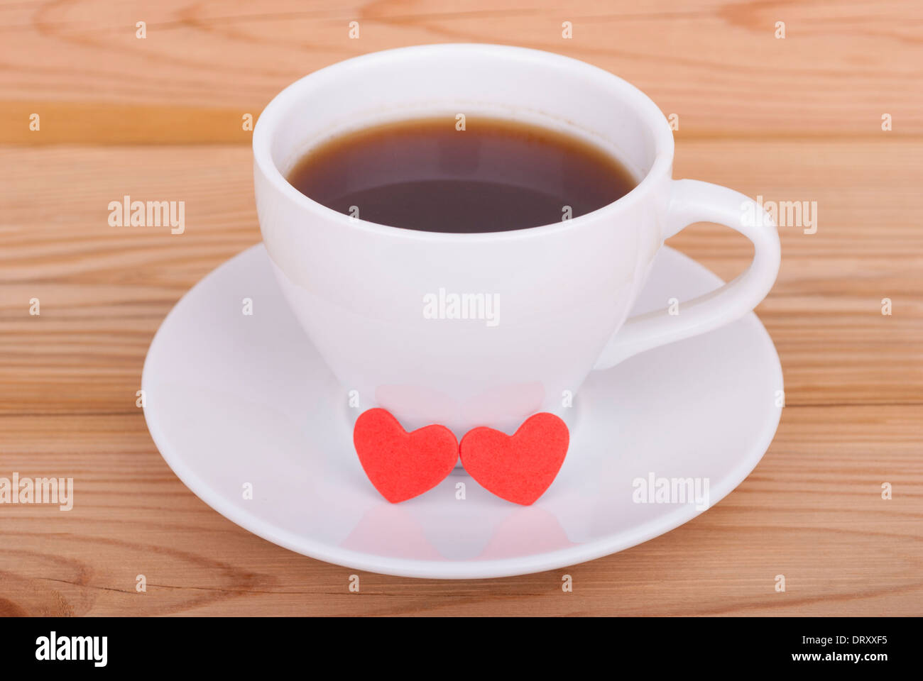 Tazza di tè e due cuori rossi. Foto Stock