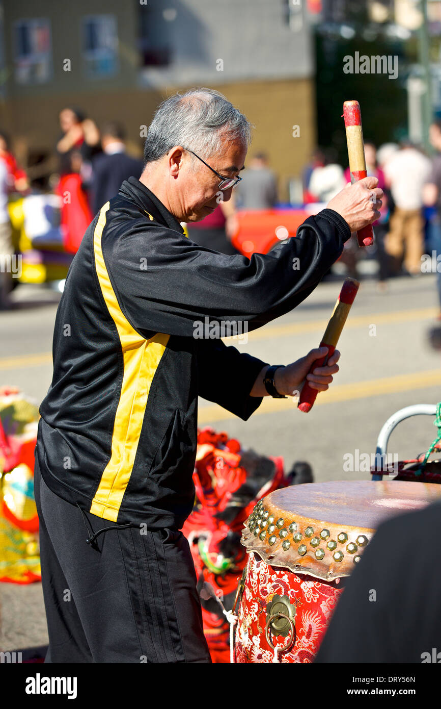 Uomo cinese suona il tamburo per un tradizionale Dragon Dance presso il Los Angeles Chinatown, sfilata di Capodanno. Foto Stock