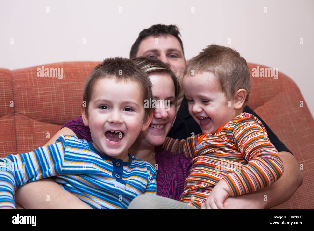Felice i genitori con bambini che si divertono a casa Foto Stock