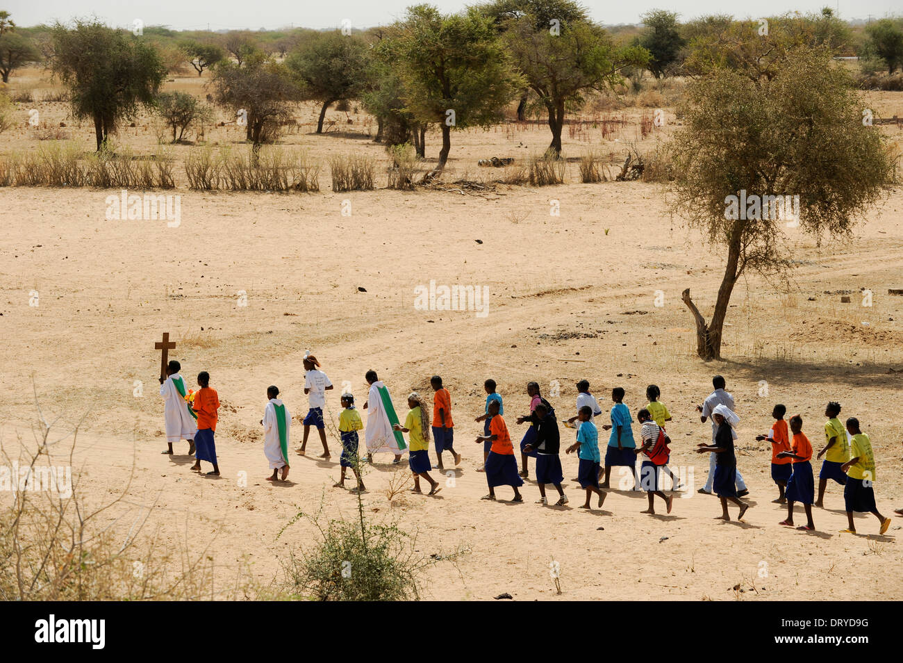 BURKINA FASO Dori, crescente terrore islamista in questa regione, questa regione è dichiarata zona rossa in relazione agli attacchi terroristici e all'insicurezza, scuola cattolica, bambini marciano di fila con la croce in savana secca Foto Stock