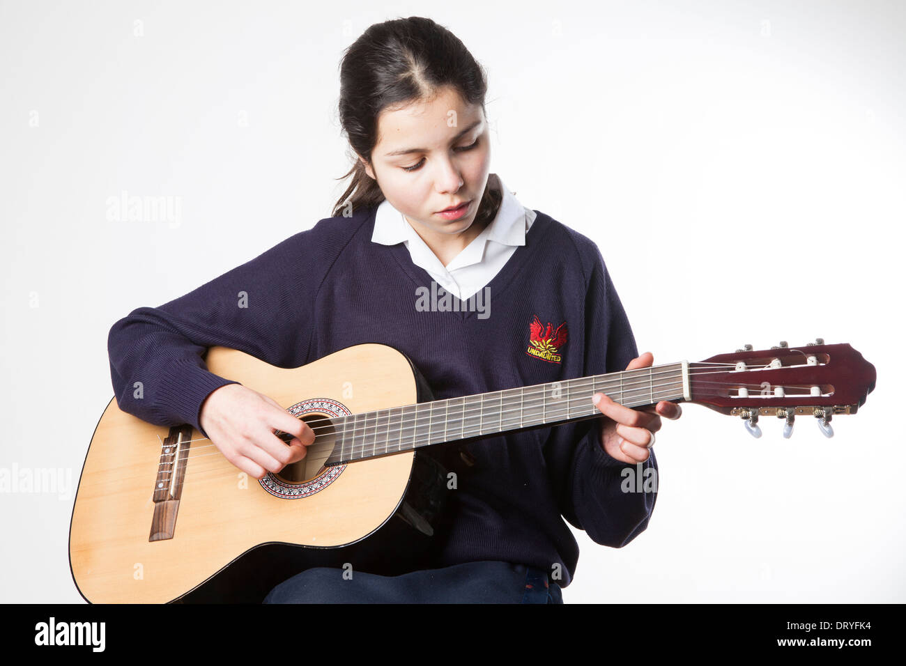 Teenage schoolgirl suona la chitarra acustica Foto Stock