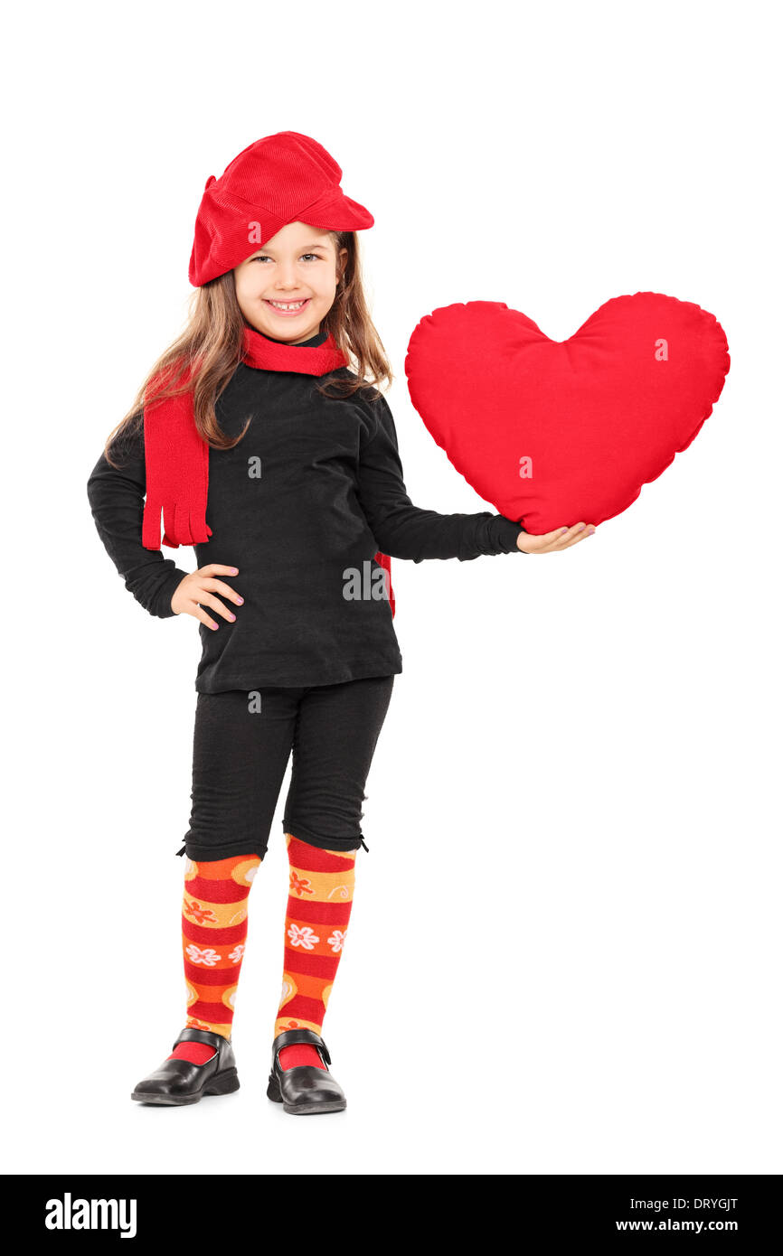 A piena lunghezza Ritratto di bambina in abiti alla moda tenendo un grande cuore rosso Foto Stock