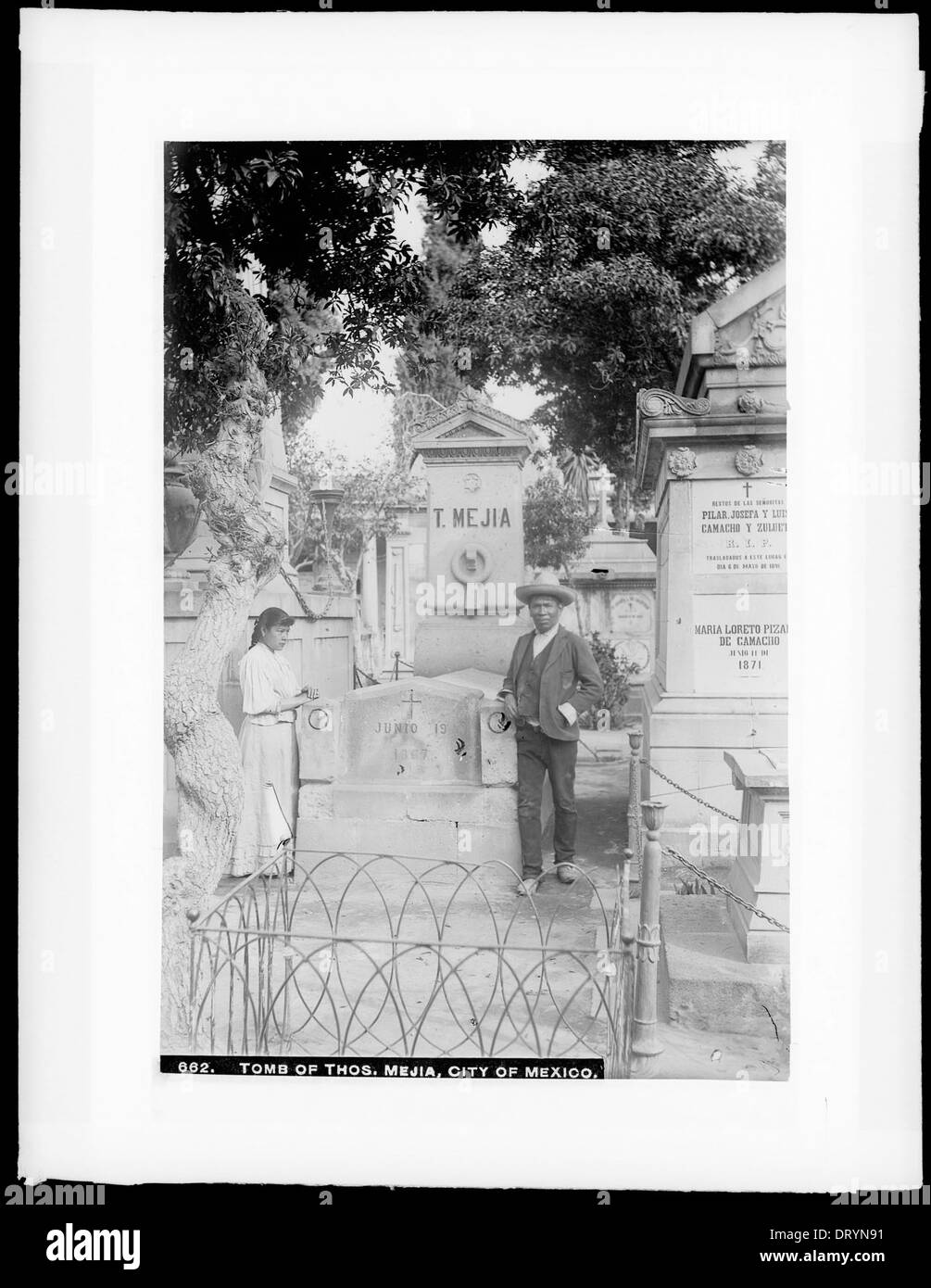 Una fotografia di un uomo e di una donna in piedi accanto alla tomba di Thomas Mejia al cimitero di San Fernando a città del Messico, scattata tra il 1905 e il 1910, che cattura un momento di ricordo. Foto Stock
