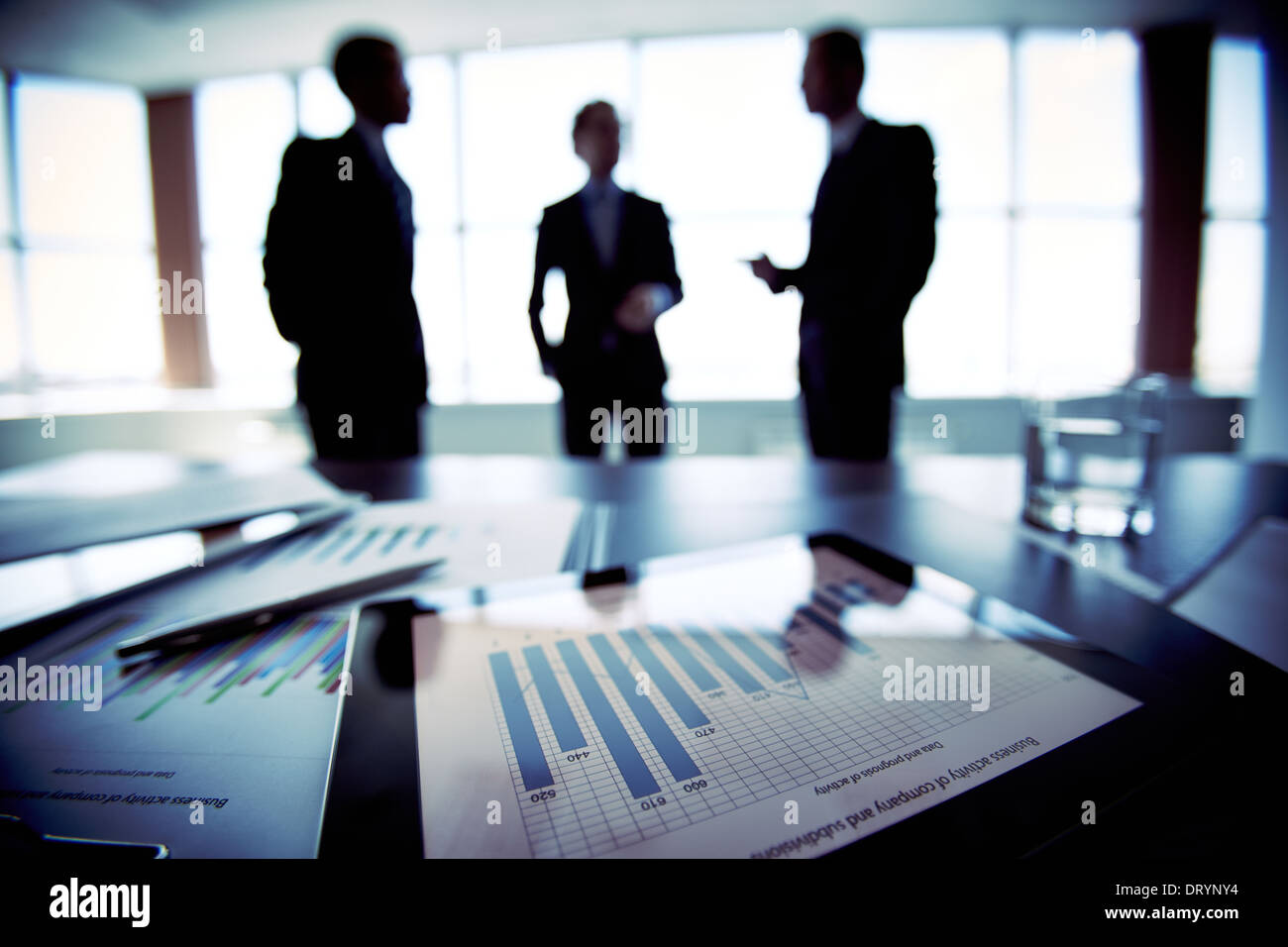 I colleghi per discutere i loro futuri piani finanziari, solo sagome essendo visualizzati Foto Stock