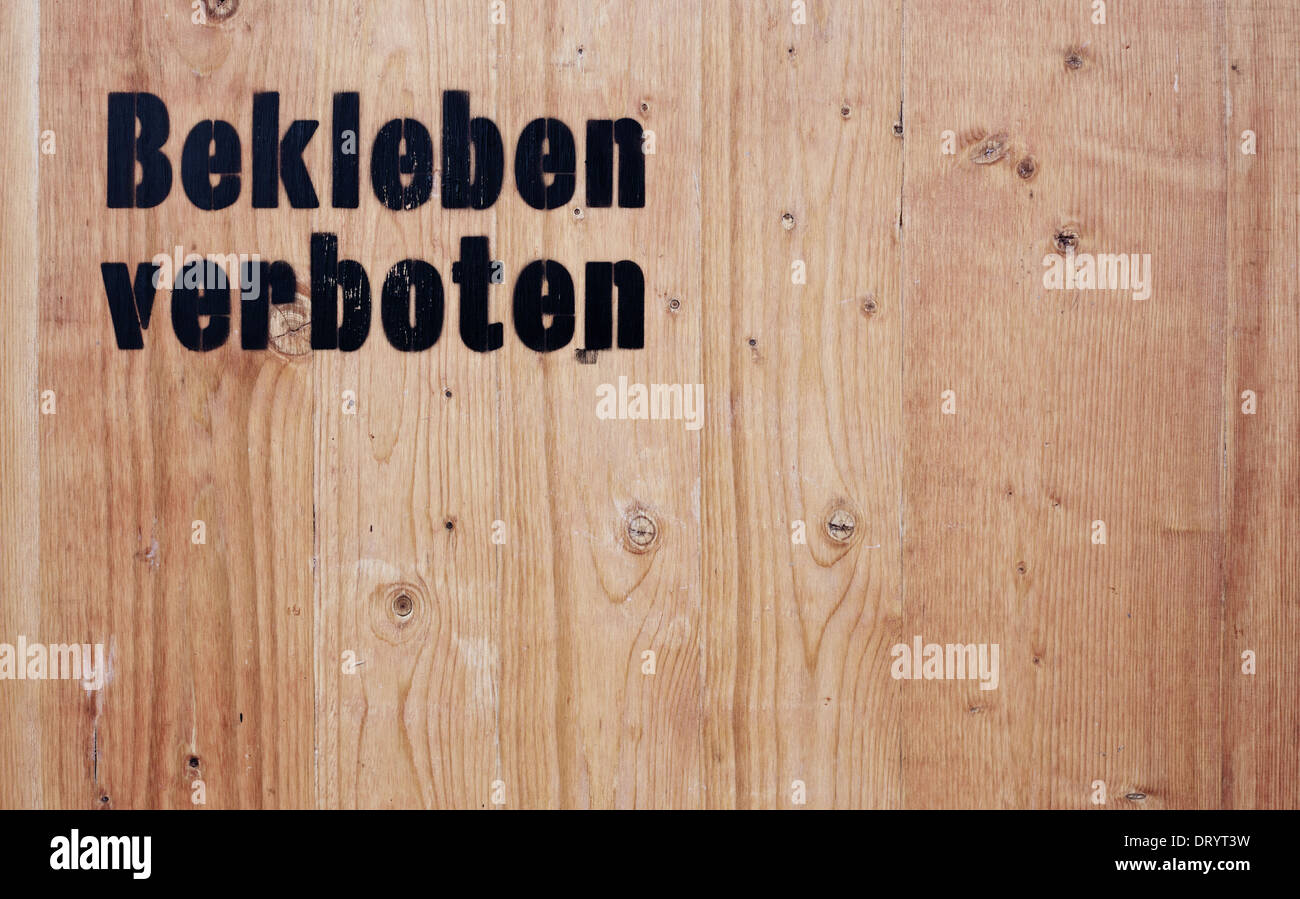 Sfondo di legno che mostra il termine tedesco bekleben verboten (in Englisch nessun incollaggio). Foto Stock