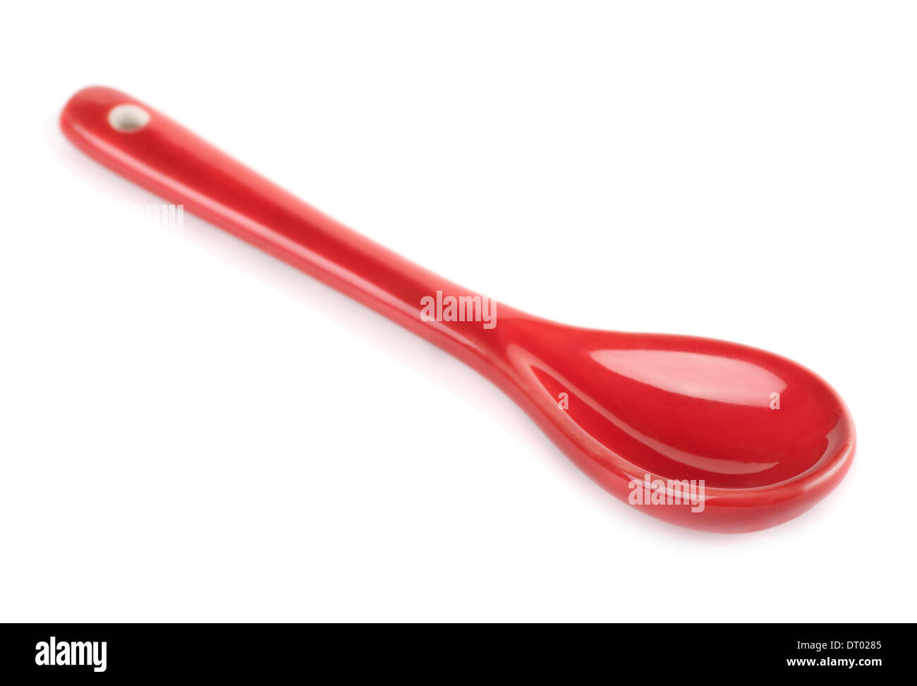 Unico rosso cucchiaio di porcellana isolato su bianco Foto Stock